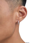 Model wearing white gold diamond earrings by Iceman Society